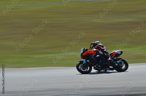 Blurred athletes practicing racing motorcycles on the race track