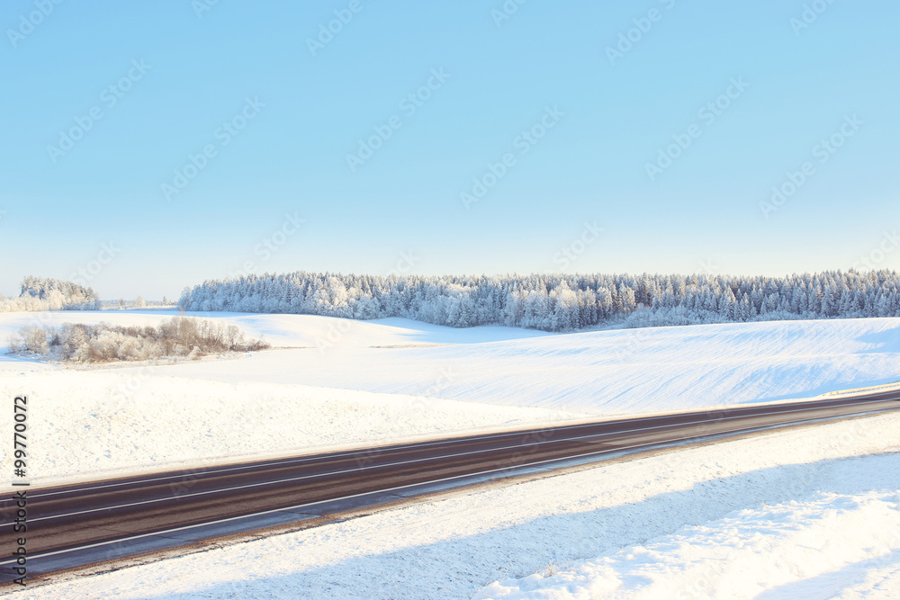 Winter. Winter road through snowy fields and forests. Winter road surrounded by snow-covered trees
