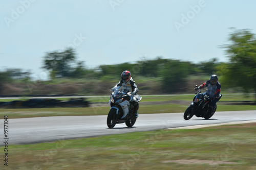 Blurred athletes practicing racing motorcycles on the race track