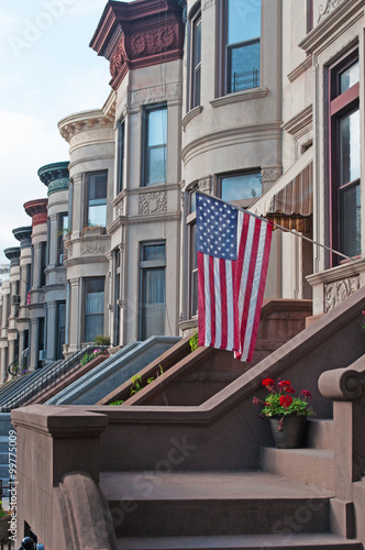 Case a schiera, tipica architettura brownstone a Brooklyn nel quartiere di Park Slope, New York, scale, fiori, bandiera americana a stelle e strisce photo