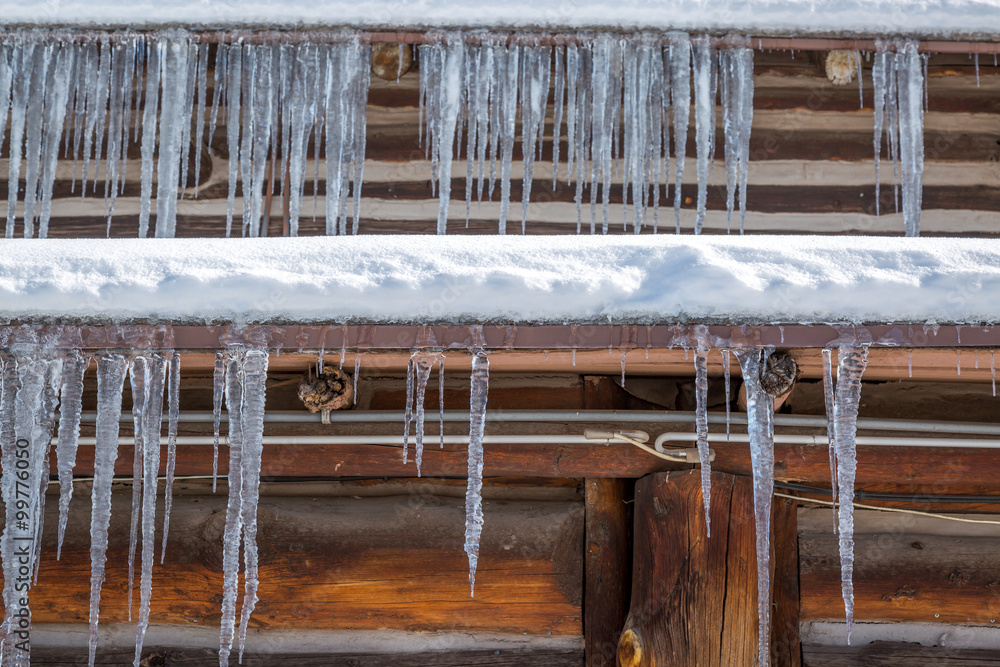 Icicles on a log cabin background. Icicles on a log cabin background.