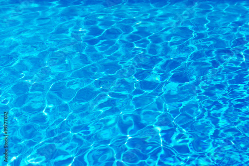 Blue pool water with sun reflections.