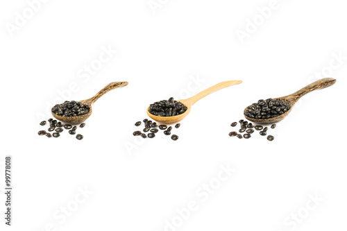 Black beans with wooden spoon isolated on white