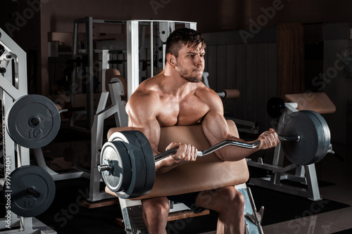 Muscular man workout with barbell