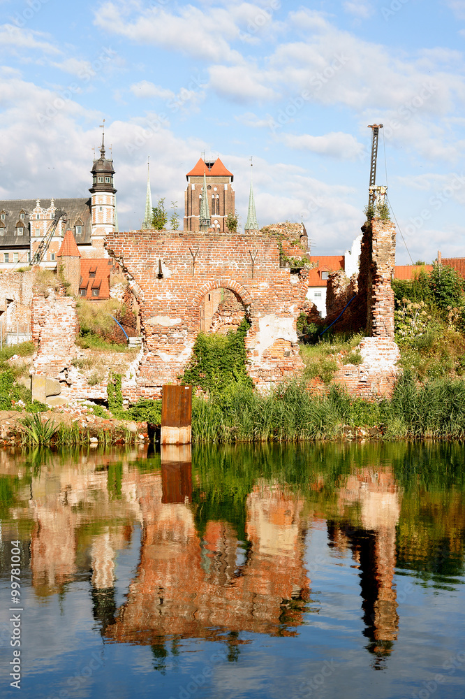 The remains of the walls of the barns Gdańsk destroyed during the Second World War, against the background of the reconstructed Gdansk Old Town