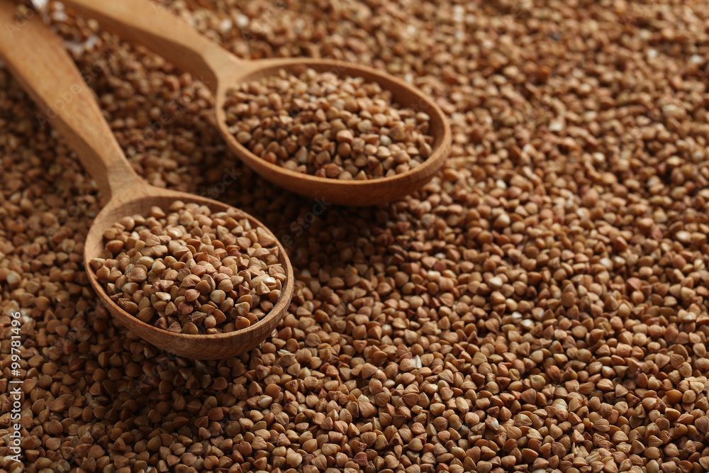 Buckwheat seeds in wooden spoon, close up Buckwheat seeds in wooden spoon, close up