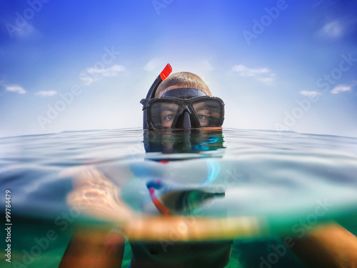Snorkeling. Selfie shot just below the surface of water. Blue sky.