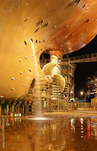 A large ship docked at the shipyard for repairs. 