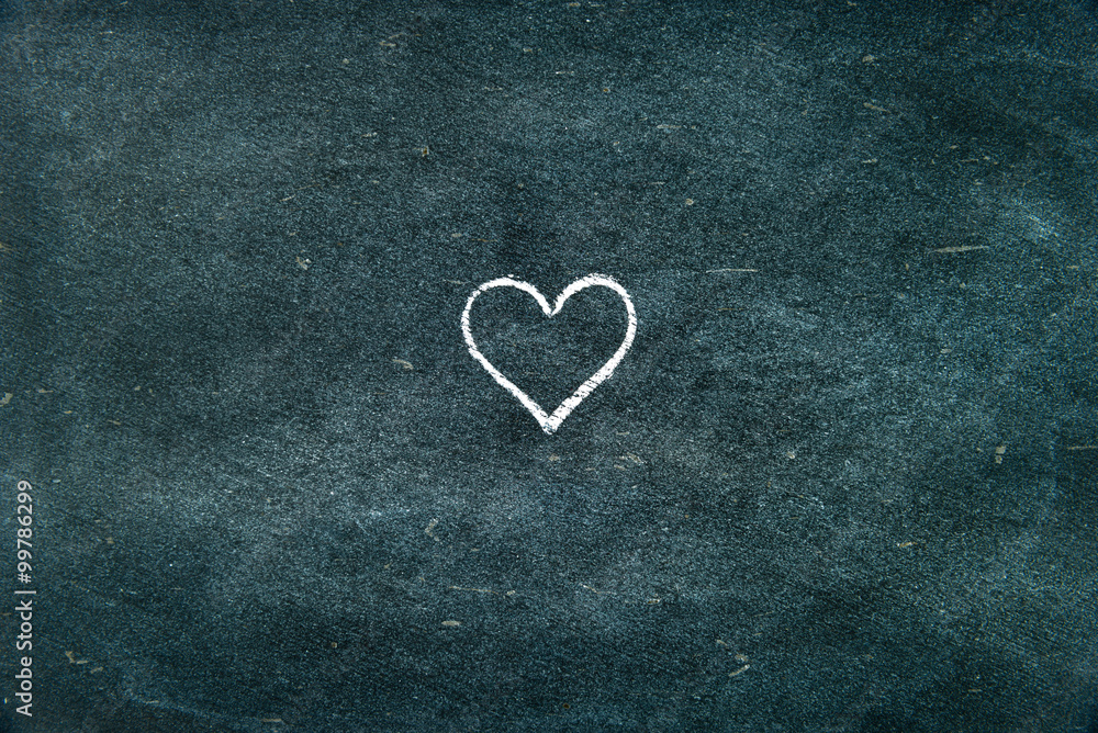 Hand drawing heart shape symbol on blackboard