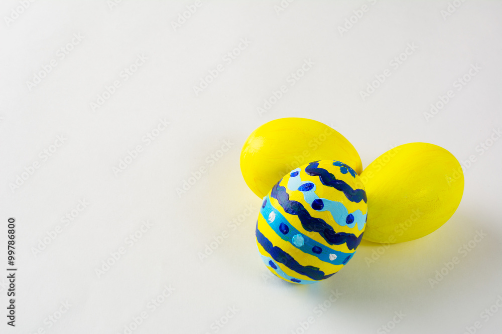 Yellow hand- decorated Easter eggs with abstract design on a white background. Easter background. Easter symbol. Copy space Yellow hand- decorated Easter eggs with abstract design on a white background. Easter background. Easter symbol. Copy space