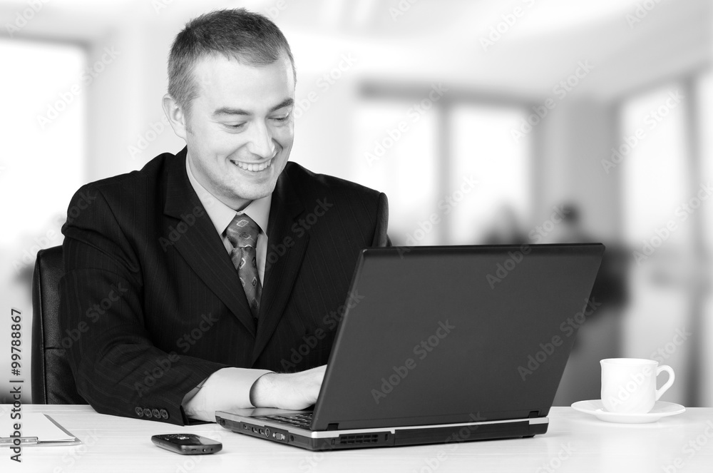 Young happy business man working on notebook Young happy business man working on notebook