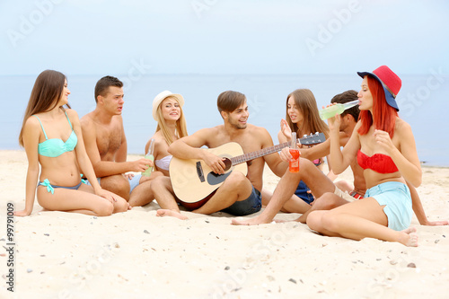 Beautiful young people with guitar having fun on beach © Africa Studio