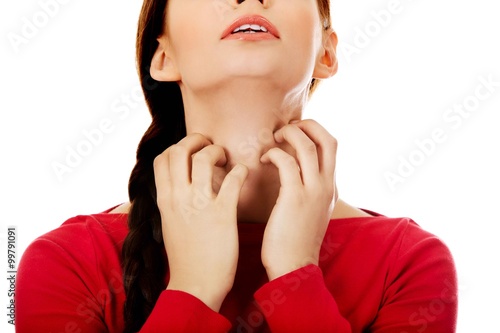 Young woman is scratching her neck