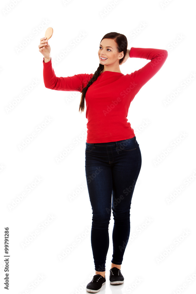 Young beautiful woman looking in a mirror Young beautiful woman looking in a mirror