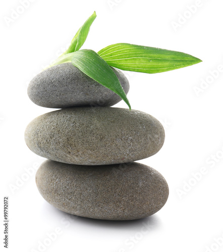 Grey spa stones and green flower  isolated on white