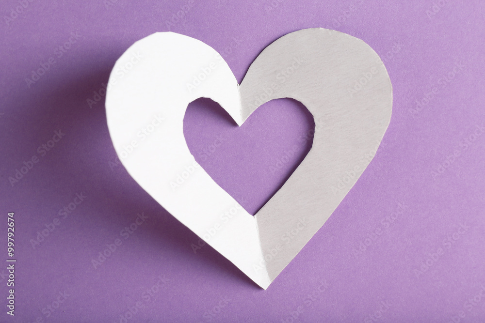 Cut out white paper heart on purple background