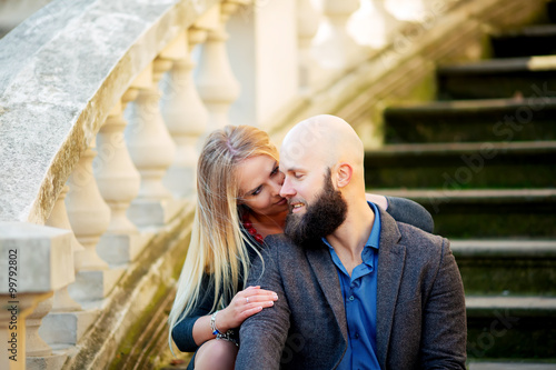 Young couple in love, hugging on the street. Selective focus. bald guy with a beard