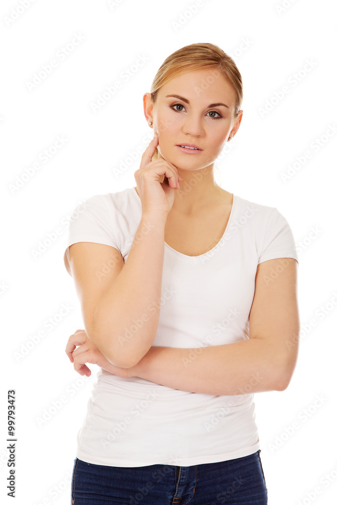 Young woman with folded hands and finger on cheek Young woman with folded hands and finger on cheek