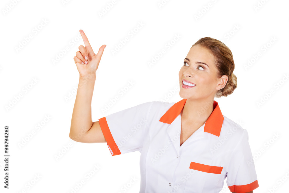 Smiling female doctor or nurse pointing at something Smiling female doctor or nurse pointing at something