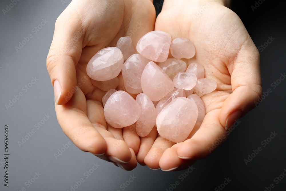 Woman holding semiprecious stones in her hands on dark grey background Woman holding semiprecious stones in her hands on dark grey background