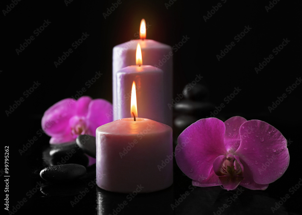 Composition of orchid, pebbles and candles in a row on dark background Composition of orchid, pebbles and candles in a row on dark background