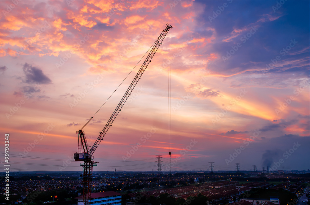 Hoisting tower crane with sunset cloud background