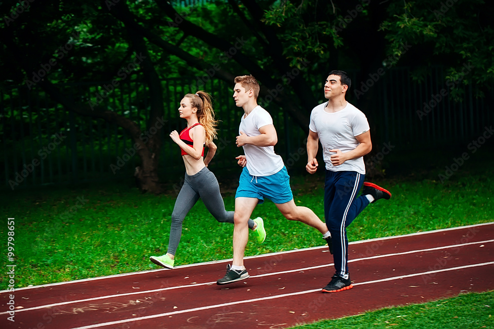 Fototapeta premium Running young people at stadium track