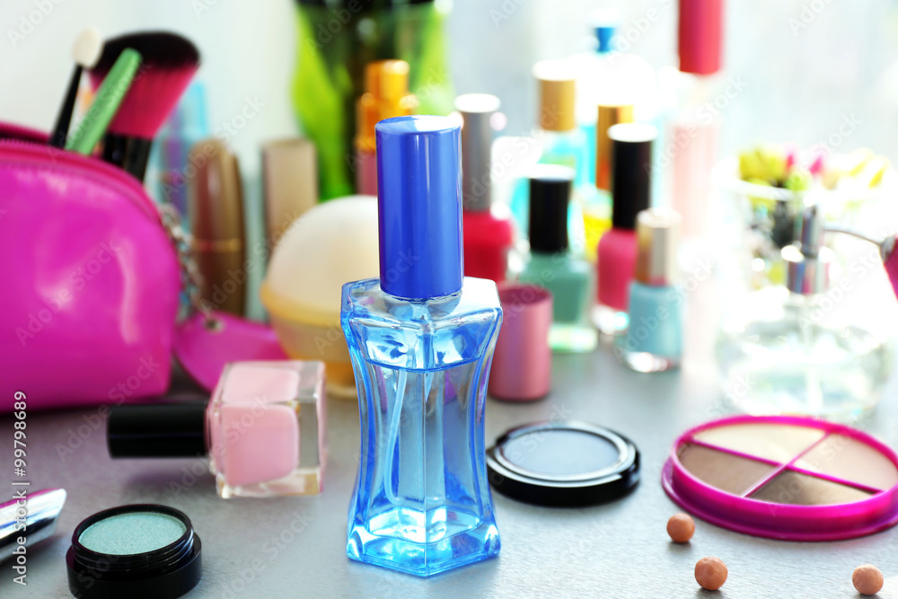 Perfume bottle with makeup tools and cosmetics on a table Perfume bottle with makeup tools and cosmetics on a table