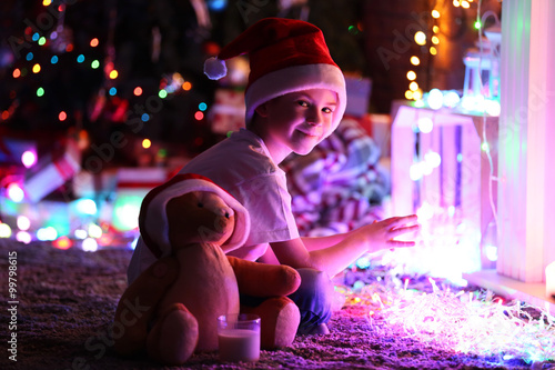 Little boy in Santa hat sit...