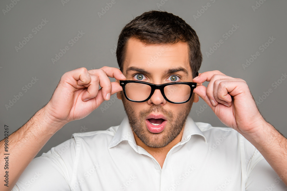 Surprised man touching glasses Surprised man touching glasses