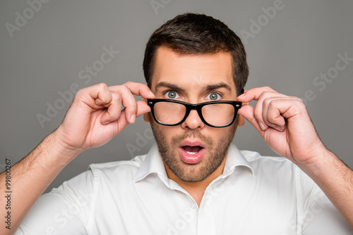 Surprised man touching glasses