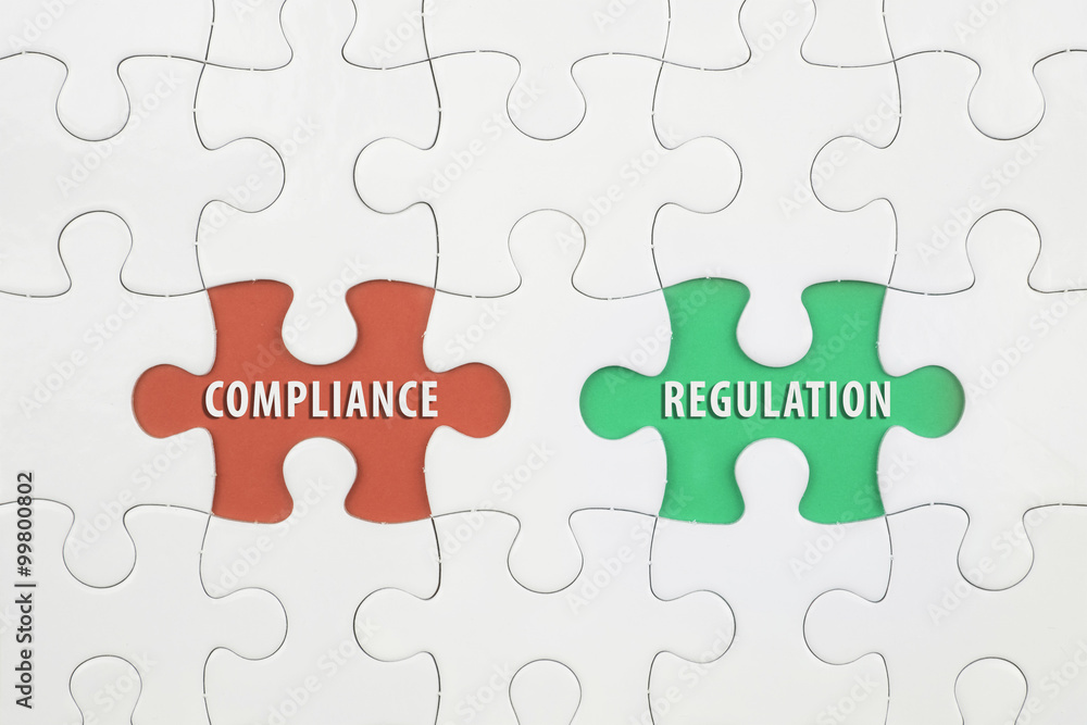 Jigsaw puzzle on color paper background with a word COMPLAINCE and REGULATION Jigsaw puzzle on color paper background with a word COMPLAINCE and REGULATION