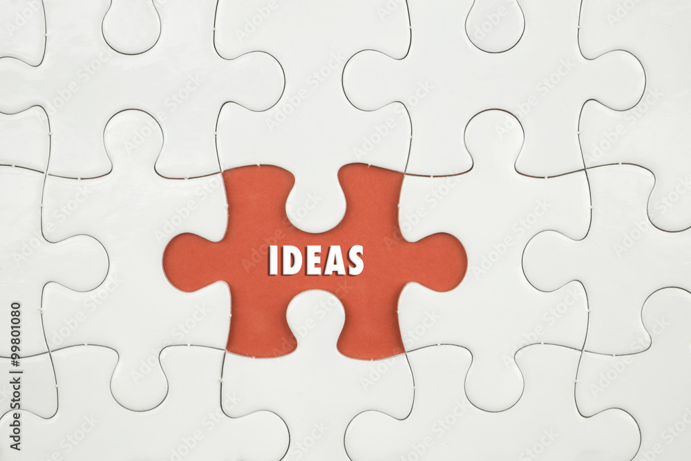 Jigsaw puzzle on color paper background with a word IDEAS Jigsaw puzzle on color paper background with a word IDEAS