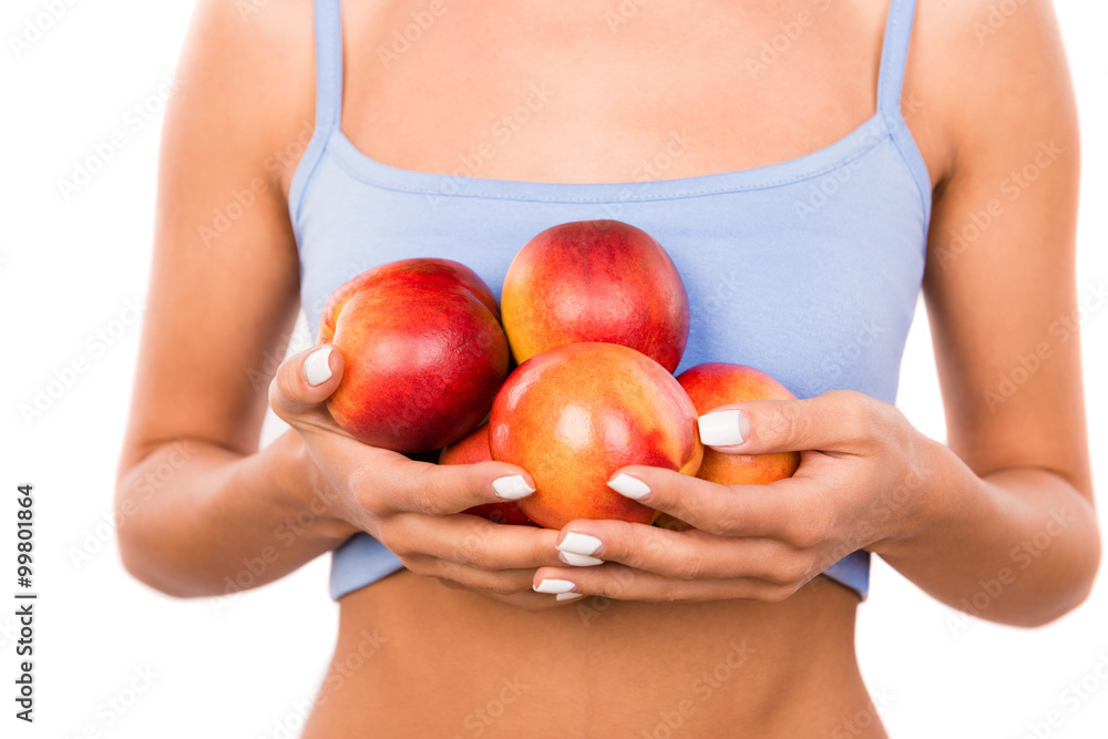 Slender healthy woman holding nectarines Slender healthy woman holding nectarines