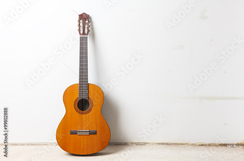 Old classical acoustic guitar on white wall background