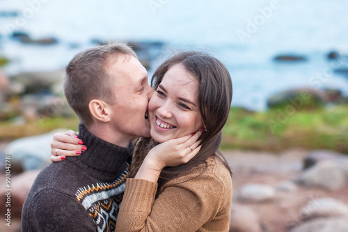 Loving couple hugging and kisses on the rocky beach