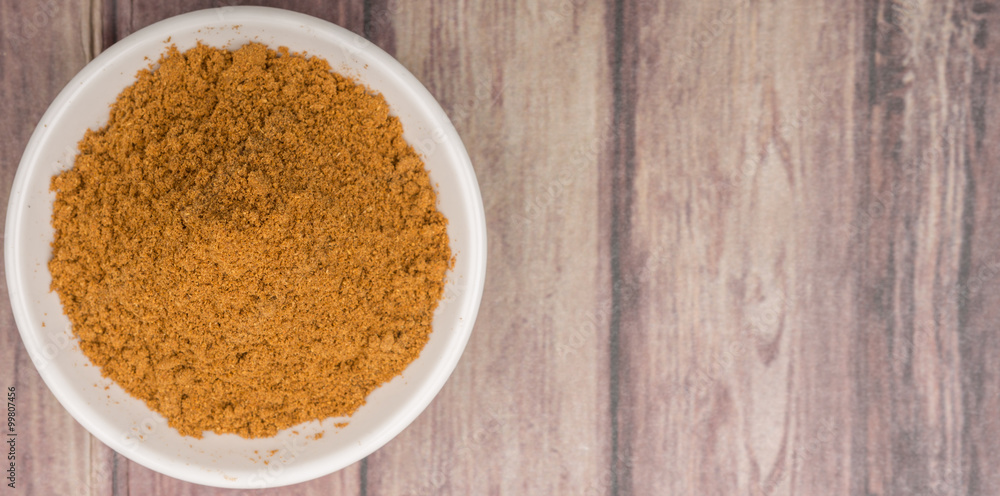Garam masala or mix spices blend in white bowl over wooden background Garam masala or mix spices blend in white bowl over wooden background