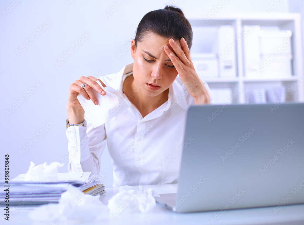 Stressed businesswoman sitting at desk in the office Stressed businesswoman sitting at desk in the office