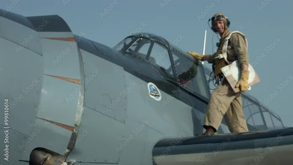 Pan to pilot re-enactor in authentic flight gear standing on airplane wing, by the cockpit of a US Navy Grumman Avenger from World War II. Close view, mute. Recorded in 4K, ultra high definition. Pan to pilot re-enactor in authentic flight gear standing on airplane wing, by the cockpit of a US Navy Grumman Avenger from World War II. Close view, mute. Recorded in 4K, ultra high definition.