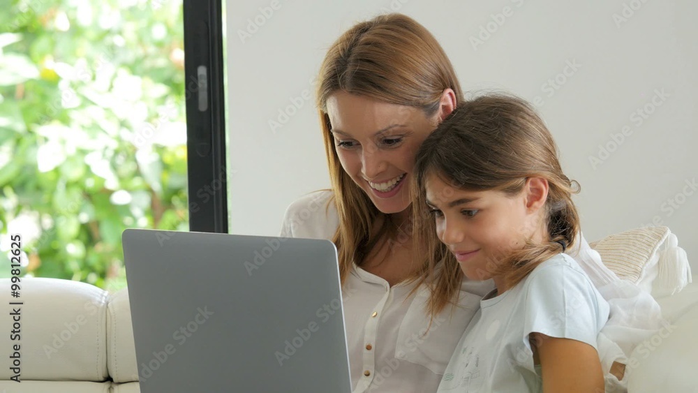 Woman with young girl using laptop computer Woman with young girl using laptop computer