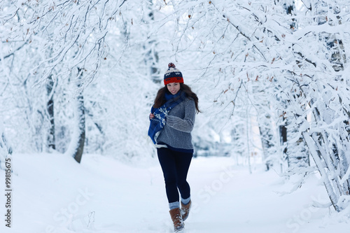 Adult girl in a sweater in the winter snowy forest