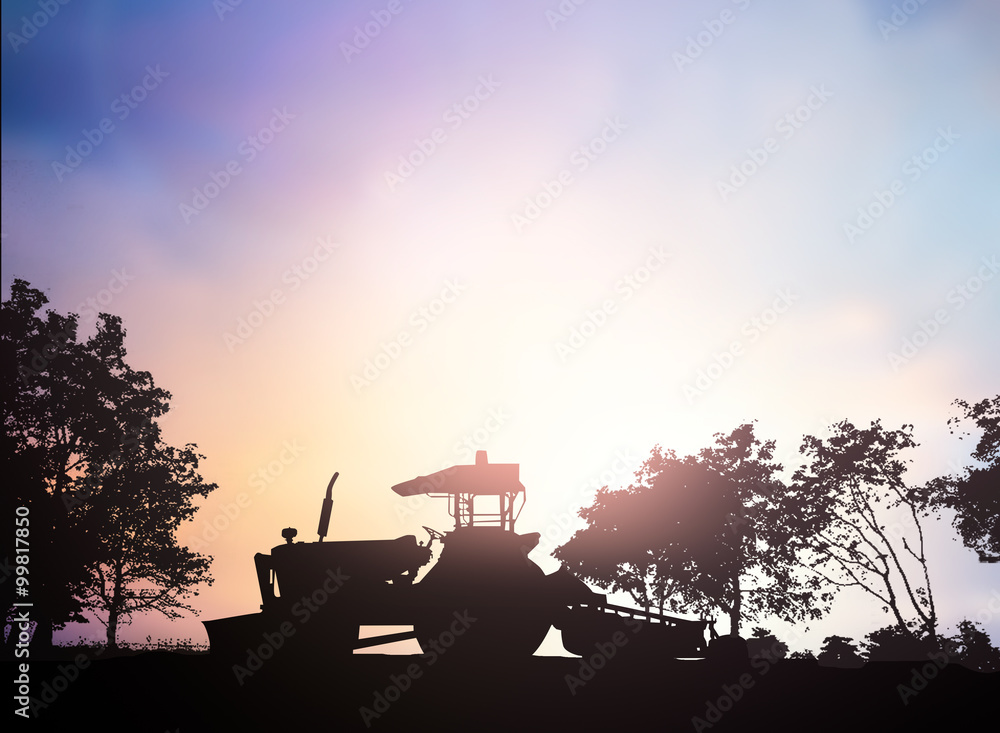 Silhouette Harvesting machine on a farm planted with vegetables,