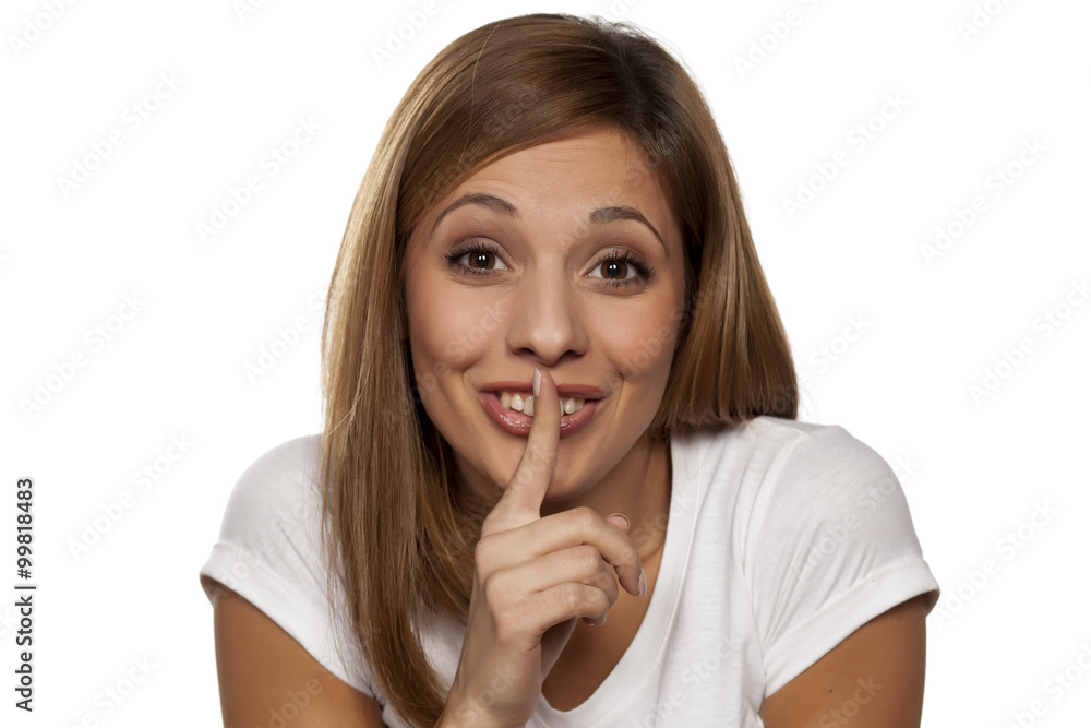 young woman with a finger on her lips - a gesture for silence young woman with a finger on her lips - a gesture for silence