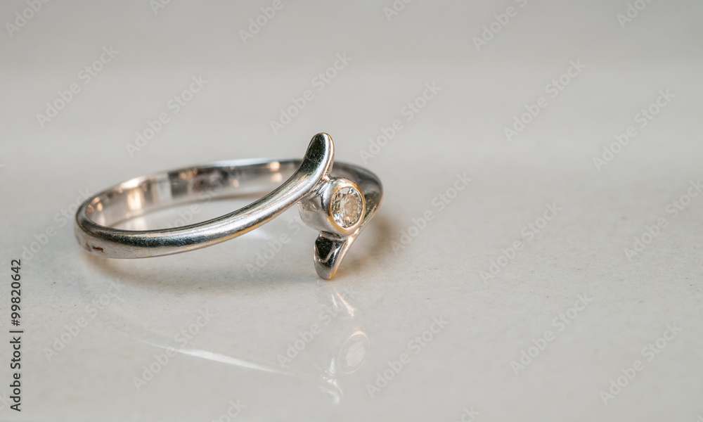 Closeup old diamond ring on blurred marble floor background Closeup old diamond ring on blurred marble floor background