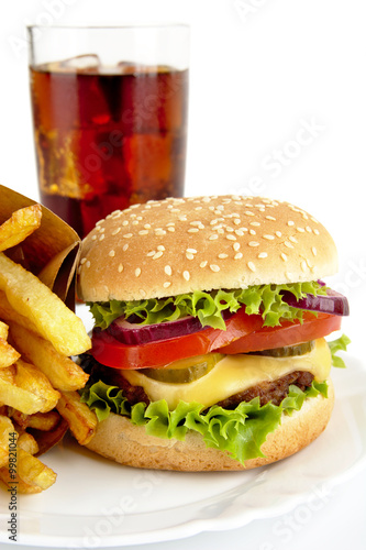 Cropped image of cheeseburger,french fries,glass of cola on plat