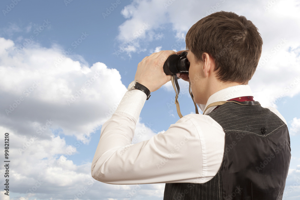 Businessman looks through a binoculars Businessman looks through a binoculars