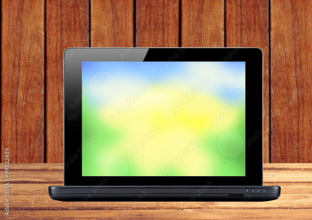 Black laptop on wooden table Black laptop on wooden table