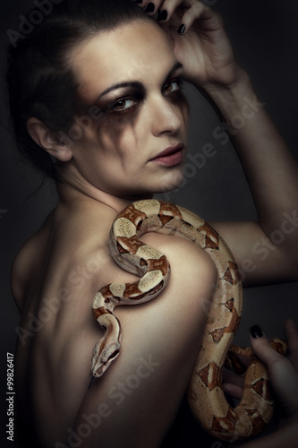 Attraktive junge brünette Frau mit Boa constrictor - Schlange
