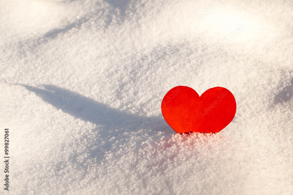 Red paper hearts in the snow.