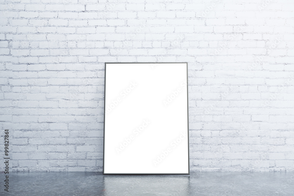 Blank white picture frame on concrete floor in empty room with w Blank white picture frame on concrete floor in empty room with w